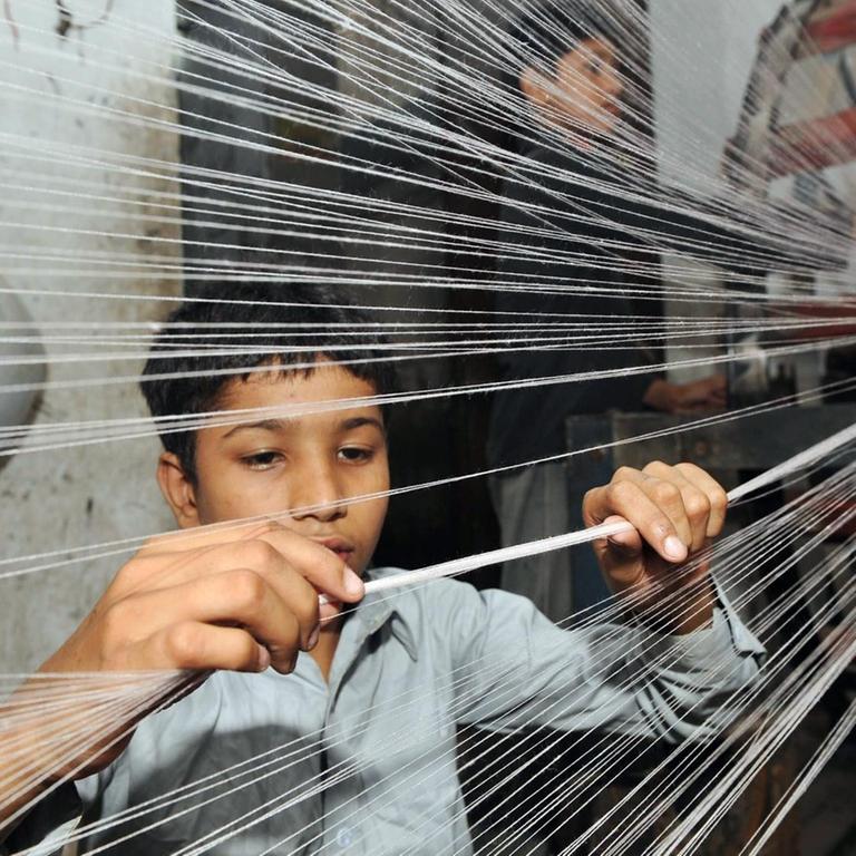 Ein Junge in einer Textilfabrik in Lahore, Pakistan.