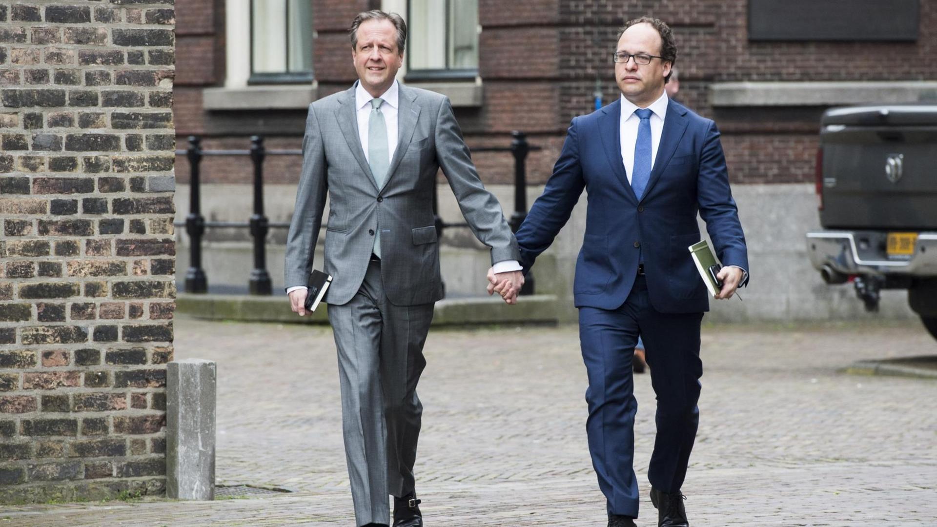 Alexander Pechtold (l) und Wouter Koolmees, niederländische Politiker der Democraten 66 (D66), kommen händchenhaltend zu einer Pressekonferenz. So wollten sie ein Zeichen gegen schwulenfeindliche Gewalt setzen.