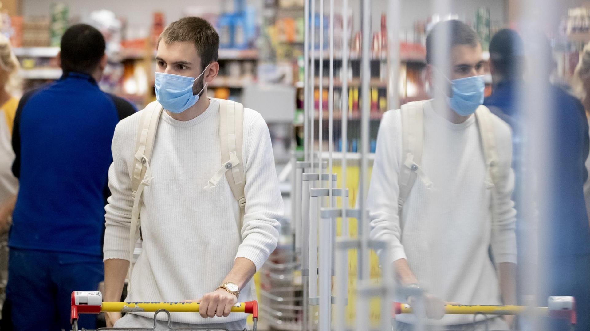 Ein Kunde geht in einem Supermarkt in Berlin-Wilmersdorf mit Mund-Nasen-Schutz einkaufen.