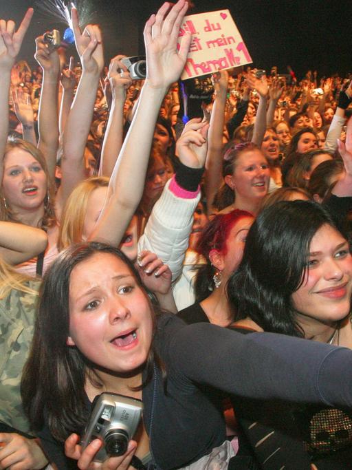 Junge Fans verfolgen begeistert das Konzert der Band Tokio Hotel.