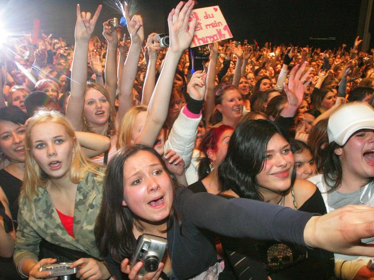 Junge Fans verfolgen begeistert das Konzert der Band Tokio Hotel.