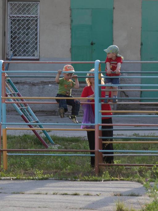Kinder spielen auf einem Spielplatz in einer Plattenbausiedlung in Ribniza, Transnistrien.