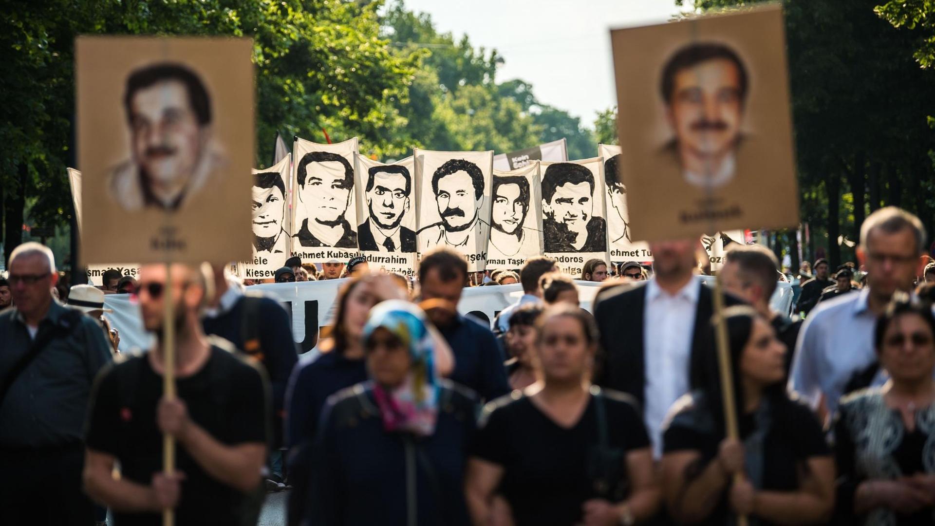 Demonstranten halten bei einer Kundgebung in München Schilder mit Porträts der NSU-Opfer.