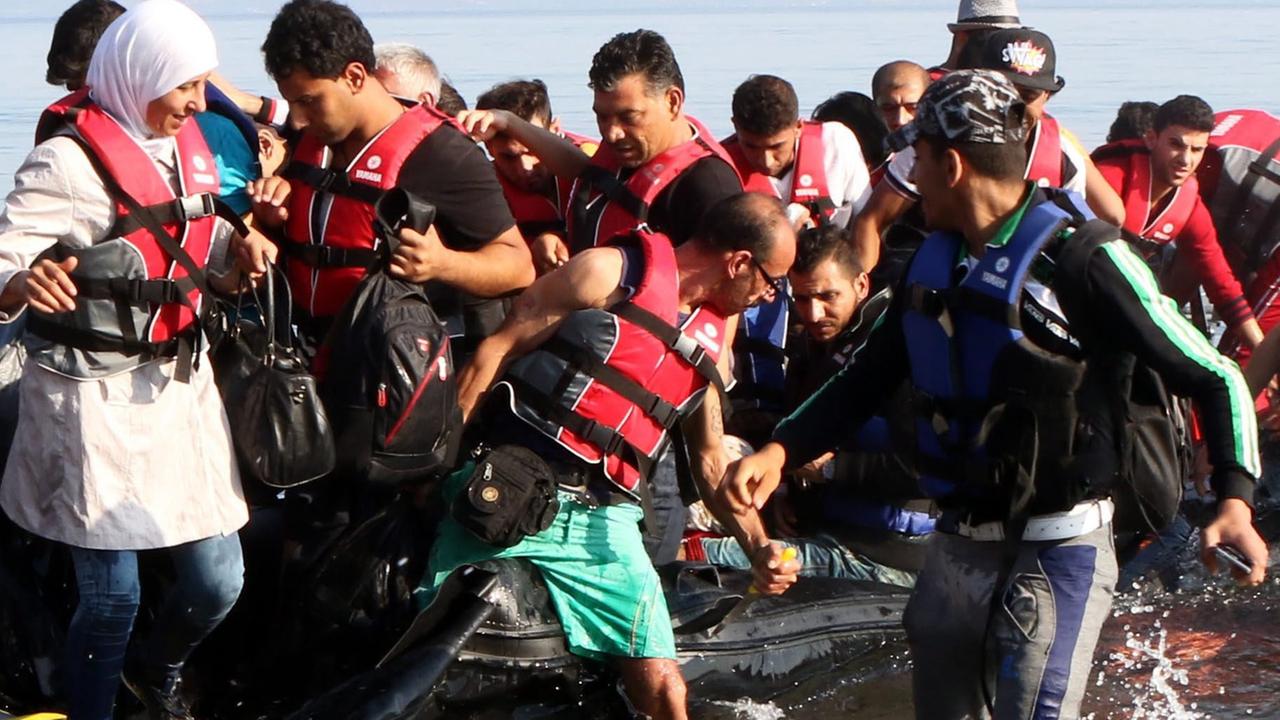 Flüchtlinge versuchen, aus einem Boot auf die Insel Lesbos zu gelangen.