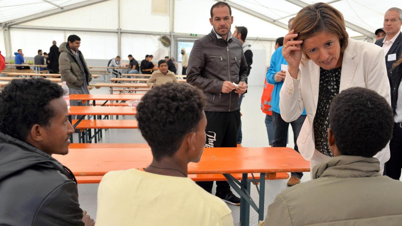 Die rheinland-pfälzische Ministerpräsidentin Malu Dreyer (r, SPD) spricht im August in dem Aufenthaltszelt auf dem Flughafen Frankfurt-Hahn in Lautzenhausen mit Bewohnern.