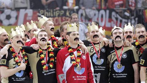 Die deutsche Handball- Nationalmannschaft zeigt nach dem Sieg im Finale ihre Begeisterung für Trainer Heiner Brand und dessen Schnäuzer.