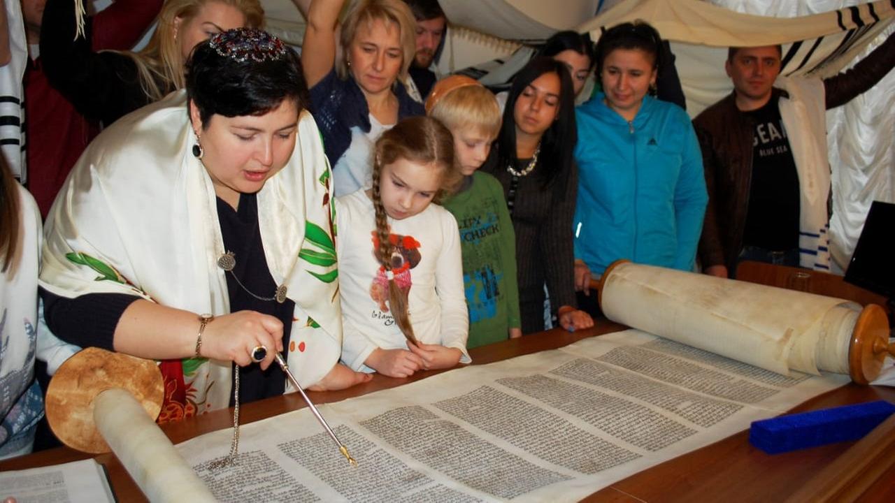 Rabbinerin Julia Gris liest mit Gemeindemitgliedern aus der Thora
