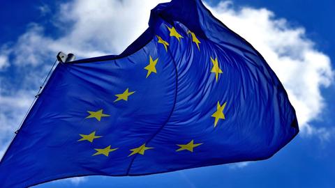 Eine EU-Fahne flattert vor fast wolkenlosem Himmel im Wind.