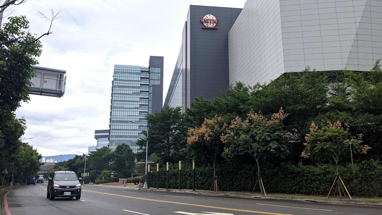 Eine Halbleiter-Fabrik im Technologiepark von TSMC in Hsinchu: graues Gebäude, neben der Straße, oben ist das Logo zu erkenn.