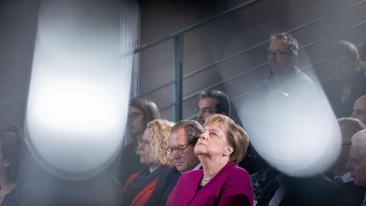 Bundeskanzlerin Angela Merkel sitzt im Publikum und schau nach oben
