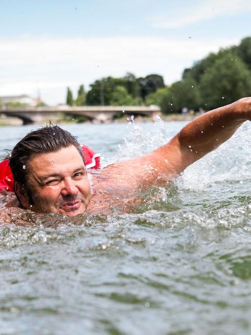 Benjamin David schwimmt am 28.06.2017 in der Isar in München. Um überfüllten Straßen und Radwegen zu entgehen, schwimmt David regelmäßig vom Flussufer vor seiner Wohnung rund zwei Kilometer an den Kulturstrand am Deutschen Museum.