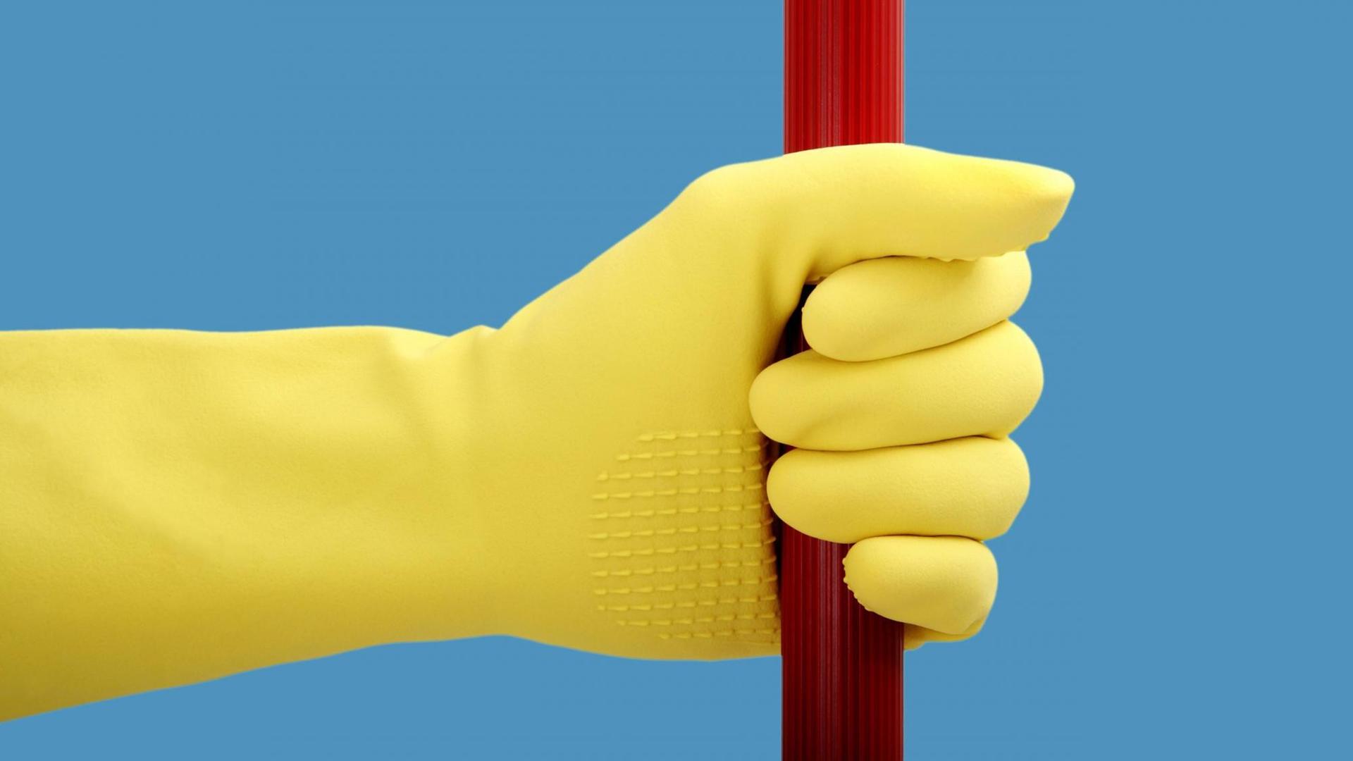 Eine Hand mit Gummihandschuh hält eine rote Stange
