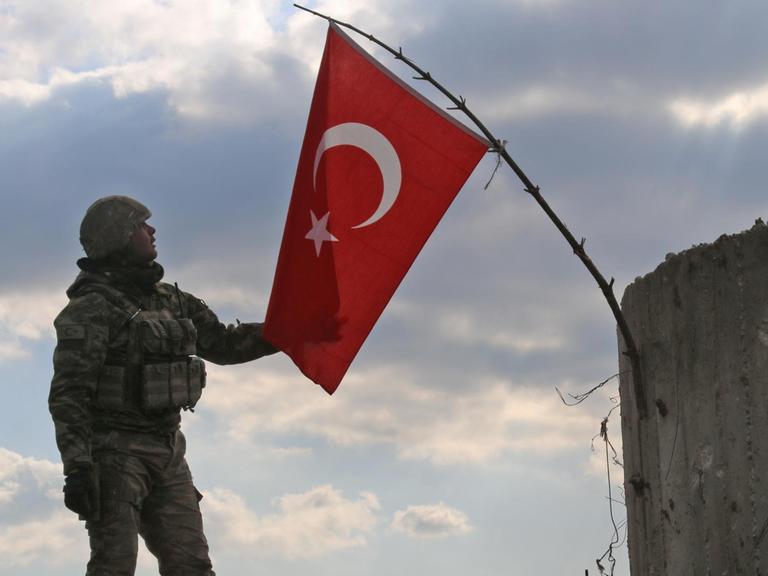 Ein türkischer Soldat mit einer Landesflagge nördlich von Azaz in der türkisch-syrischen Grenzregion.