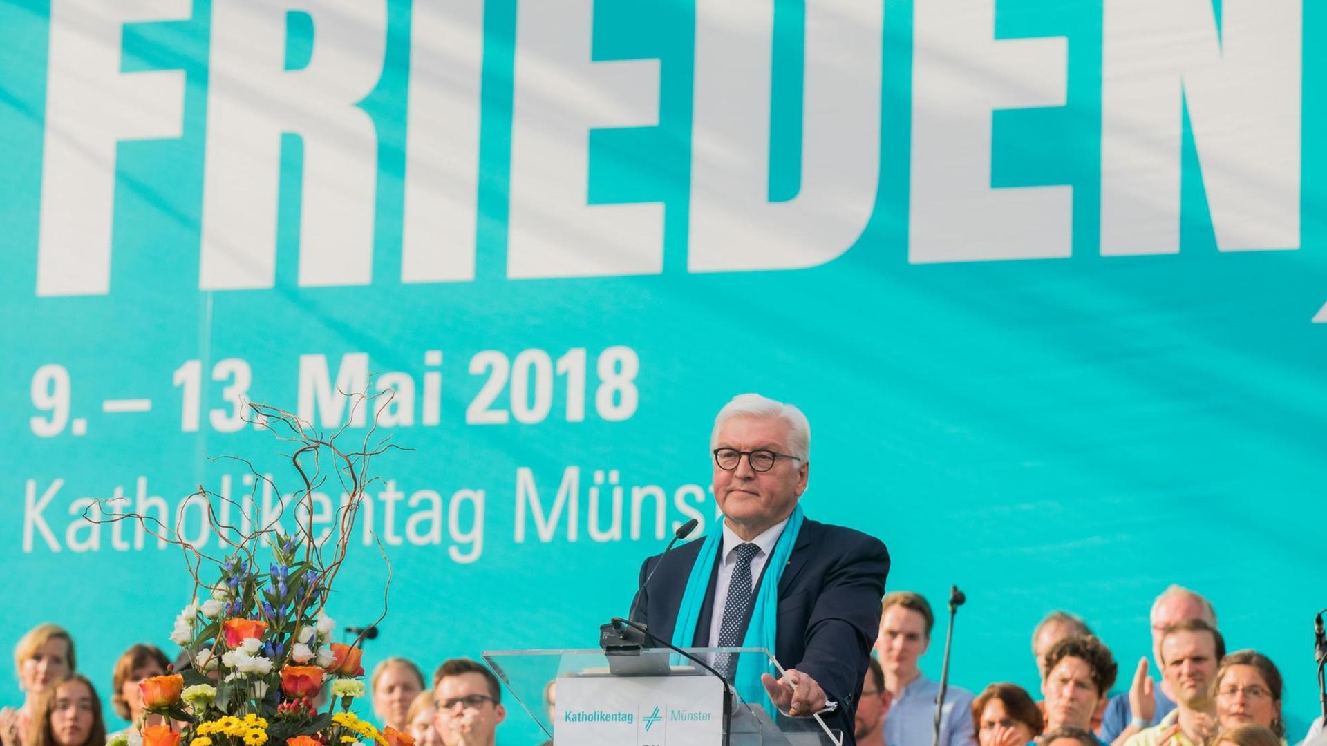 Bundespräsident Steinmeier steht hinter einem Rednerpult. Im Hintergrund ist ein blaues Banner mit dem Motto des diesjährigen Katholikentages "Suche Frieden" in weißer Schrift zu sehen.
