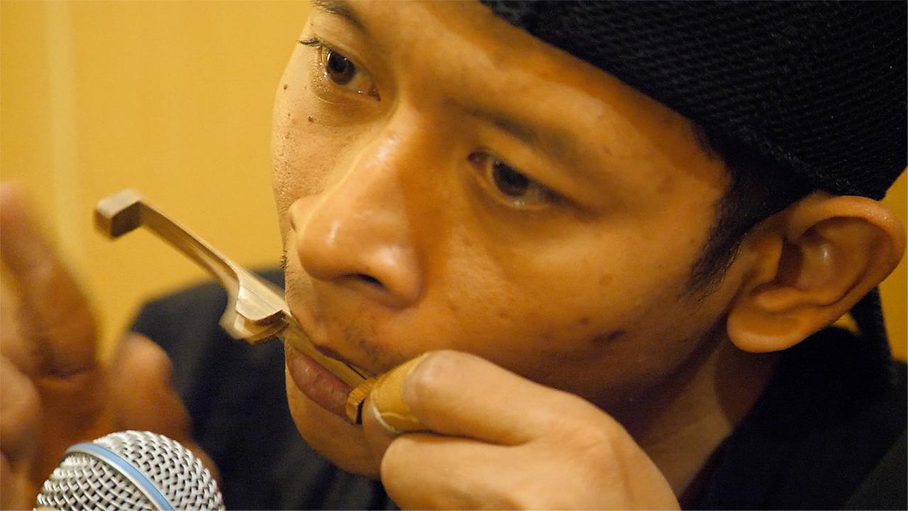 Indonesischer Musiker mit Maultrommel und Mikrophon