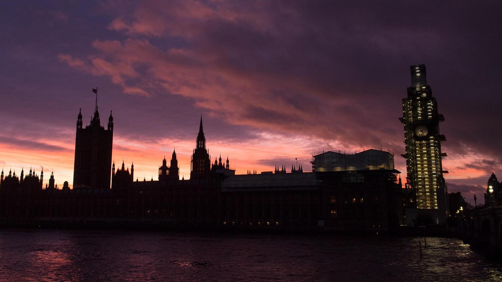 Das Foto zeigt das britische Parlament an der Themse im Abendlicht.