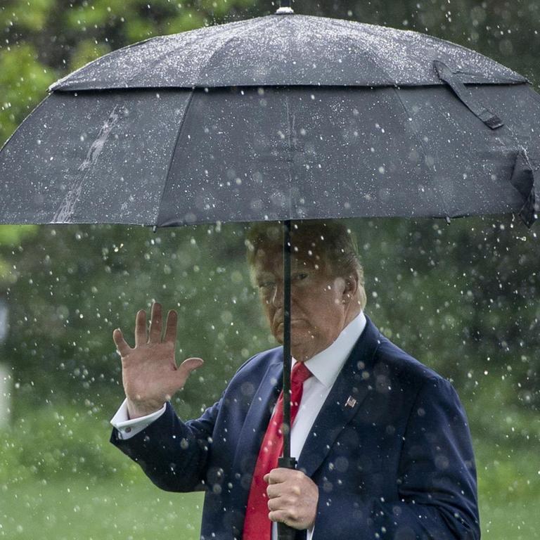Donald Trump im Regen auf dem Weg zur "Marine One" vor dem weissen Haus in Washington, auf dem Weg nach Dallas, Texas. 2020.