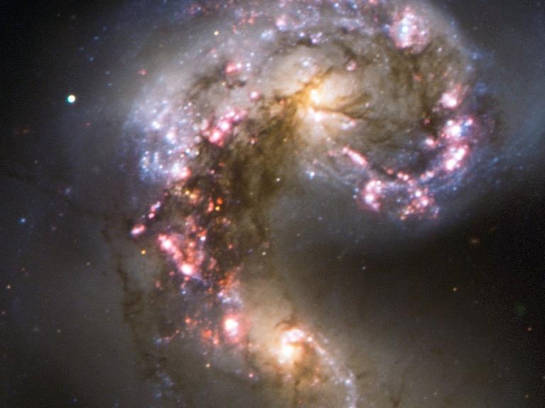 Die Antennen-Galaxien, bei denen zwei Sternsysteme miteinander kollidieren, zeigen aufgrund dieser Kollision derzeit eine extreme Sternentstehungsrate.