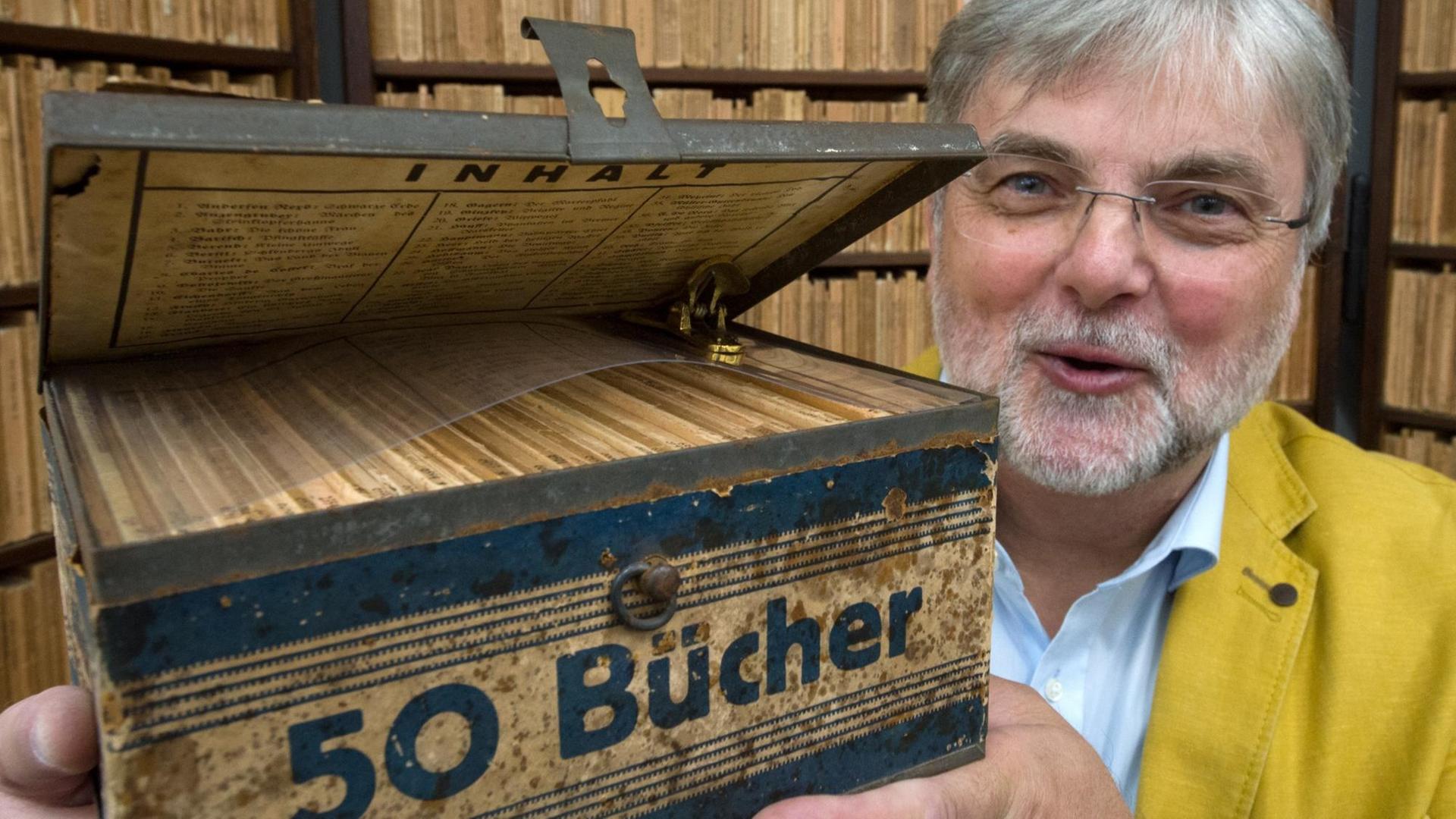 Hans-Jochen Marquardt, Vorsitzender des Literarischen Museums und Initiator der Reclam-Ausstellung, zeigt im Reclam-Museum in Leipzig eine Ausgabe der Reclam Wochenend-Bücherei, die zwischen 1927 und 1930 in einer Blechkassette auf den Markt kam.