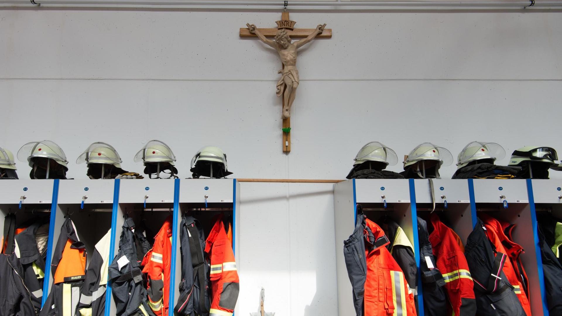 Ein Kruzifix hängt bei der Freiwilligen Feuerwehr in Allersberg (Bayern) über der Garderobe in der Fahrzeughalle.