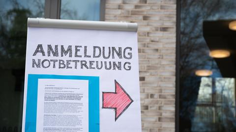 Ein Flipchart mit der Aufschrift «Anmeldung Notbetreuung» steht auf dem Gelände der Grundschule Hoheluft in Hamburg.