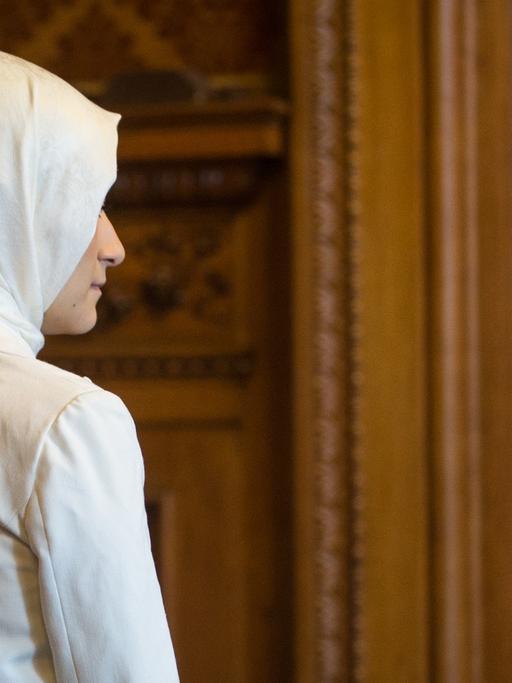Eine Teilnehmerin der Jungen Islam Konferenz läuft am 27.09.2014 in Hamburg durch das Rathaus. Die Junge Islam Konferenz ist ein Dialogforum junger Menschen im Alter zwischen 17 und 25 Jahren.