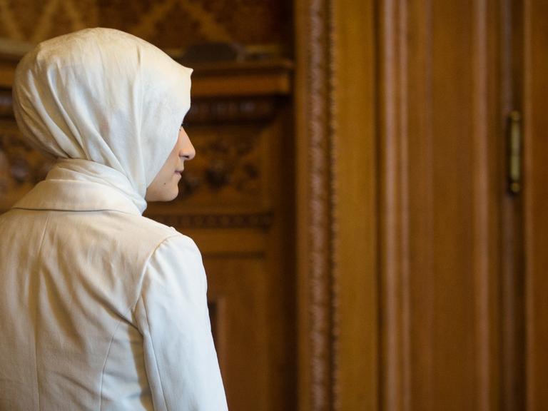 Eine Teilnehmerin der Jungen Islam Konferenz läuft am 27.09.2014 in Hamburg durch das Rathaus. Die Junge Islam Konferenz ist ein Dialogforum junger Menschen im Alter zwischen 17 und 25 Jahren.