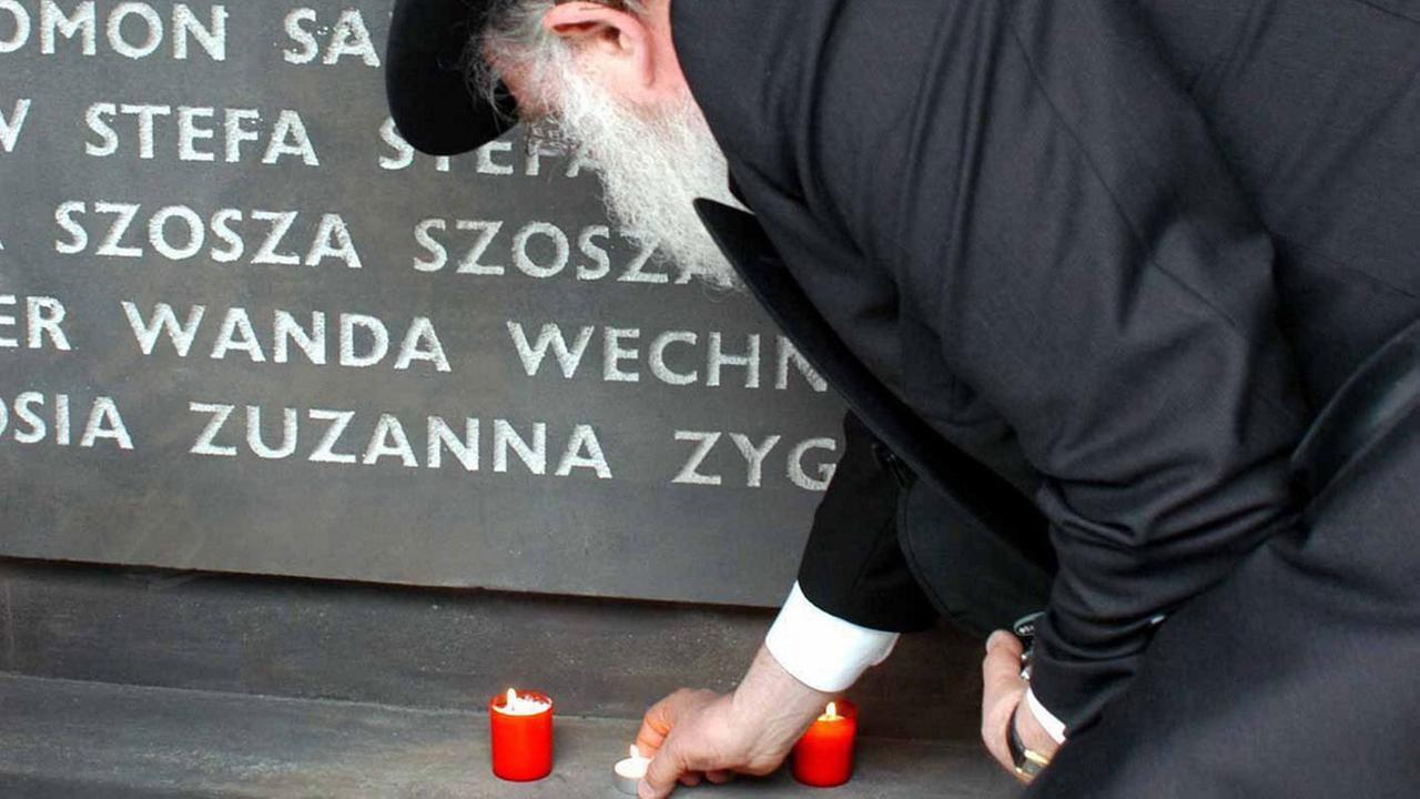 Ein Mann stellt am 3.6.2004 bei Einweihung der Gedenkstätte für die Holocaust-Opfer des ehemaligen deutschen Vernichtungslagers im ostpolnischen Belzec an einer Gedenktafel eine Kerze auf.