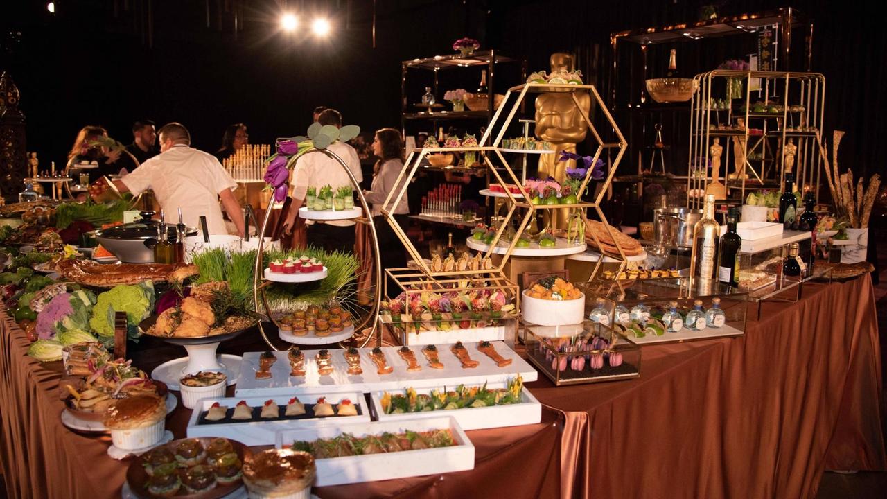 Mehrere Platten mit Speisen stehen auf einem pompös geschmückten Tisch anlässlich einer Party im Vorfeld der Oscar-Verleihung.