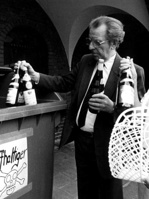 Zwei Krefelder Bürger bringen am 31. Juli 1985 Flaschen mit gepanschtem Wein zu einem eigens dafür aufgestellten Container.