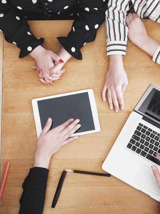 Junge Mitarbeiter im Startup diskutieren am Schreibtisch.