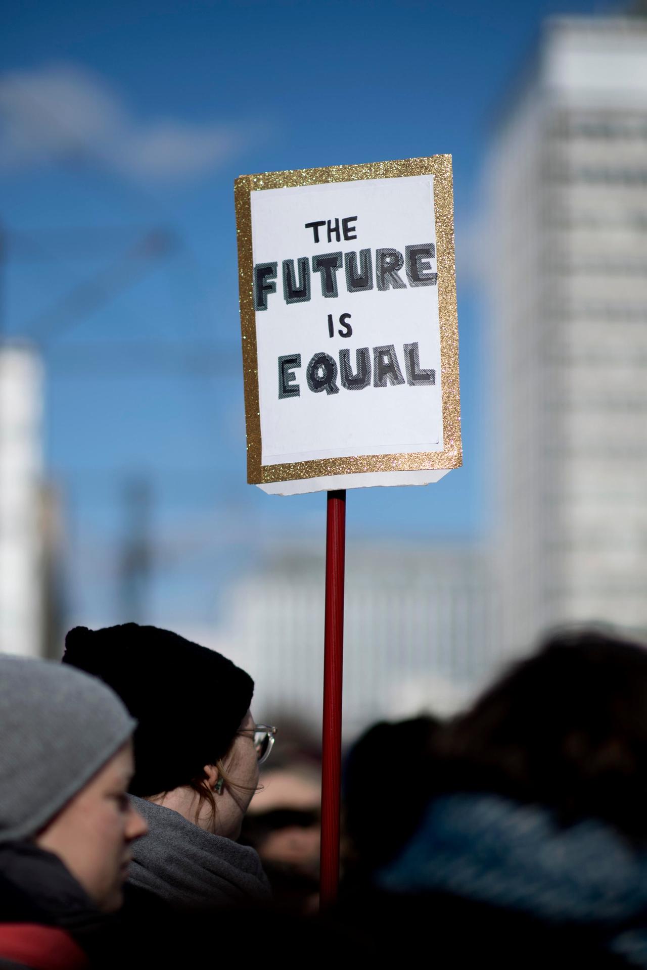 Das Foto zeigt eine Menge von Demonstrantinnen und ein Plakat mit der Aufschrift "Plakat The Future Is Equal" auf dem Internationalen Frauentag unter dem Motto Feiern Streiken Weiterkaempfen am 8. Maerz in Berlin. Das Foto zeigt eine Menge von Demonstrantinnen und ein Plakat mit der Aufschrift "Plakat The Future Is Equal" auf dem Internationalen Frauentag unter dem Motto Feiern Streiken Weiterkaempfen am 8. Maerz in Berlin.