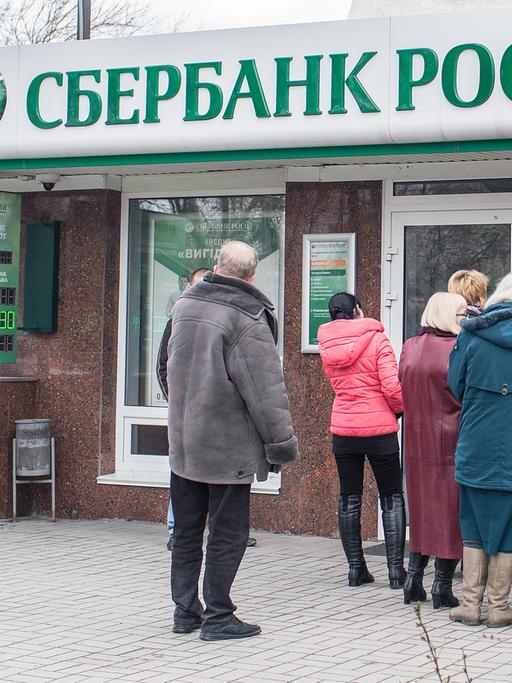 Menschen stehen am 18.03.2014 in Simferopol (Ukraine) vor einer Filiale der russischen Bank Sberbank in einer Schlange um Geld abzuheben.
