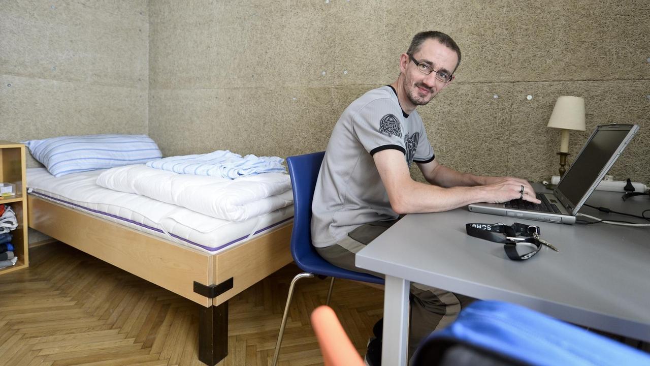Ein Bewohner des Wiener Obdachlosen-Projekts VinziRast-mittendrin in seinem Zimmer am Schreibtisch. 