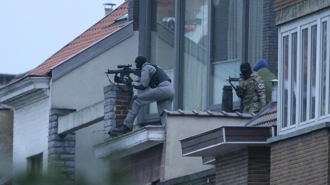 Belgische Sicherheitsleute umstellen in Brüssel das Gebäude, in dem eine Razzia stattfand.