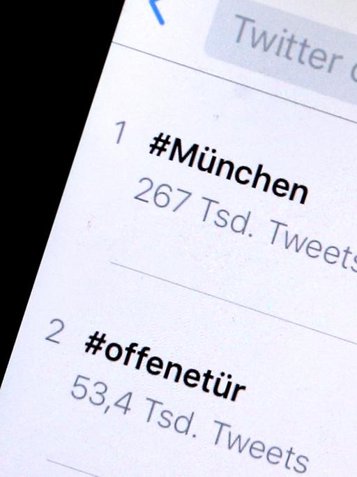 Auf einem iPhone sind Hashtags, die als Reaktion auf die Schießerei in München gepostet wurden, zu sehen. Über die Hashtags "#München" und "#offenetür" gewährten Bewohner der Stadt nach der Schießerei anderen Menschen Unterschlupf.