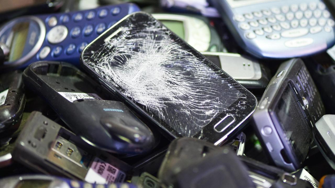 Ausgediente Mobiltelefone liegen in der Recyclingfirma Alba in einer Transportkiste, aufgenommen 2015