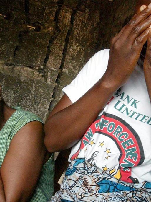Zwei Frauen halten sich die Hände vor das Gesicht. Sie wurden 2002 im Bügerkrieg in Liberia Opfer von sexueller Gewalt.