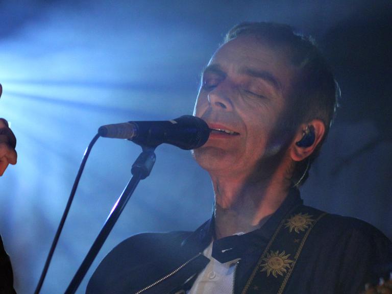 Karl Hyde, Kopf und Sänger der britischen Band "Underworld" im Scheinwerferlicht am Mikro bei einem Konzert