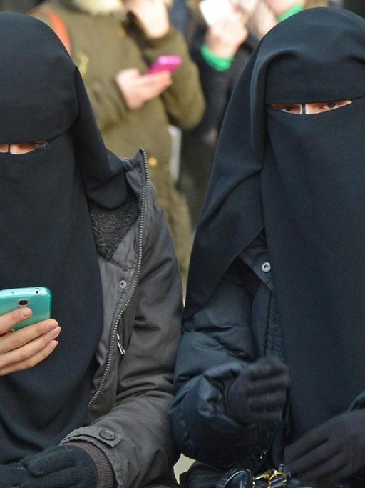 Verschleierte Frauen auf einer Kundgebung des Salafistenpredigers Pierre Vogel in Pforzheim. Eine von ihnen benutzt ein Smartphone.