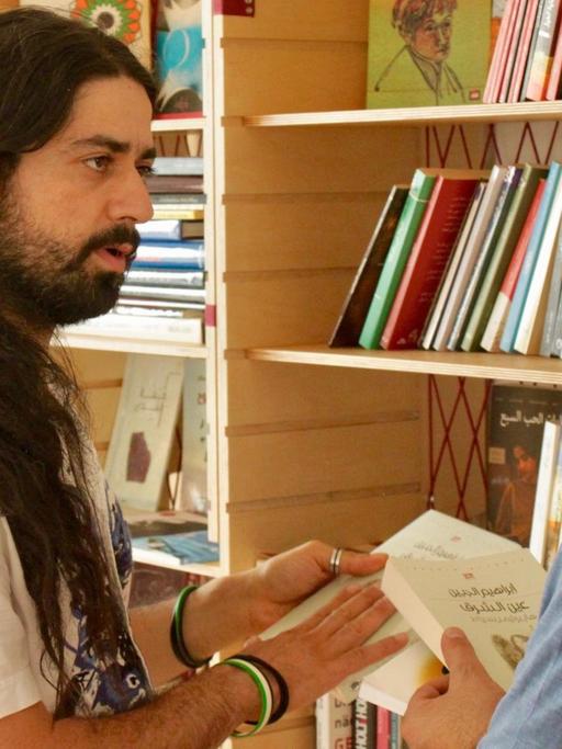 Wirbt für arabische Literatur: Muhannad Qaiconie (links) in der Bibliothek Baynatna.