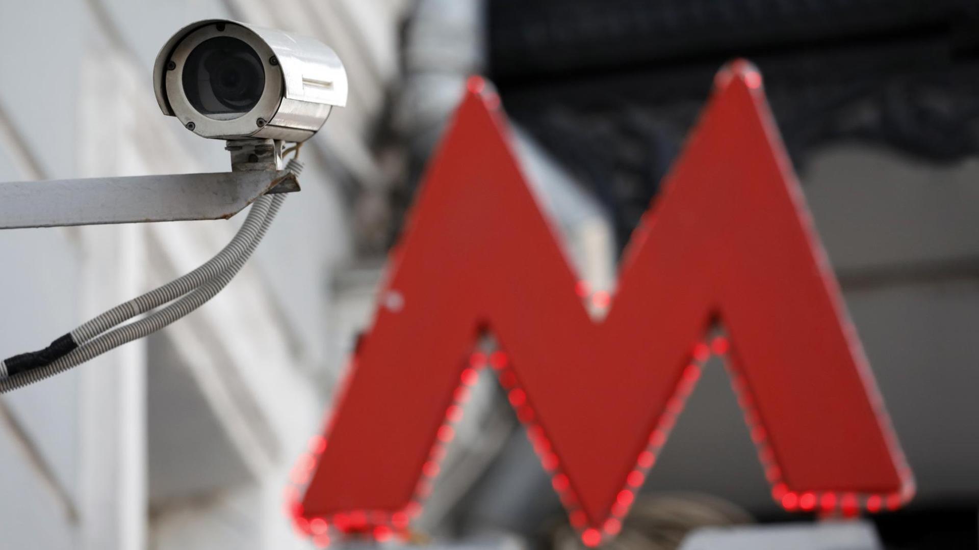 Eine Überwachungskamera neben dem roten Metro-Zeichen in Moskau
