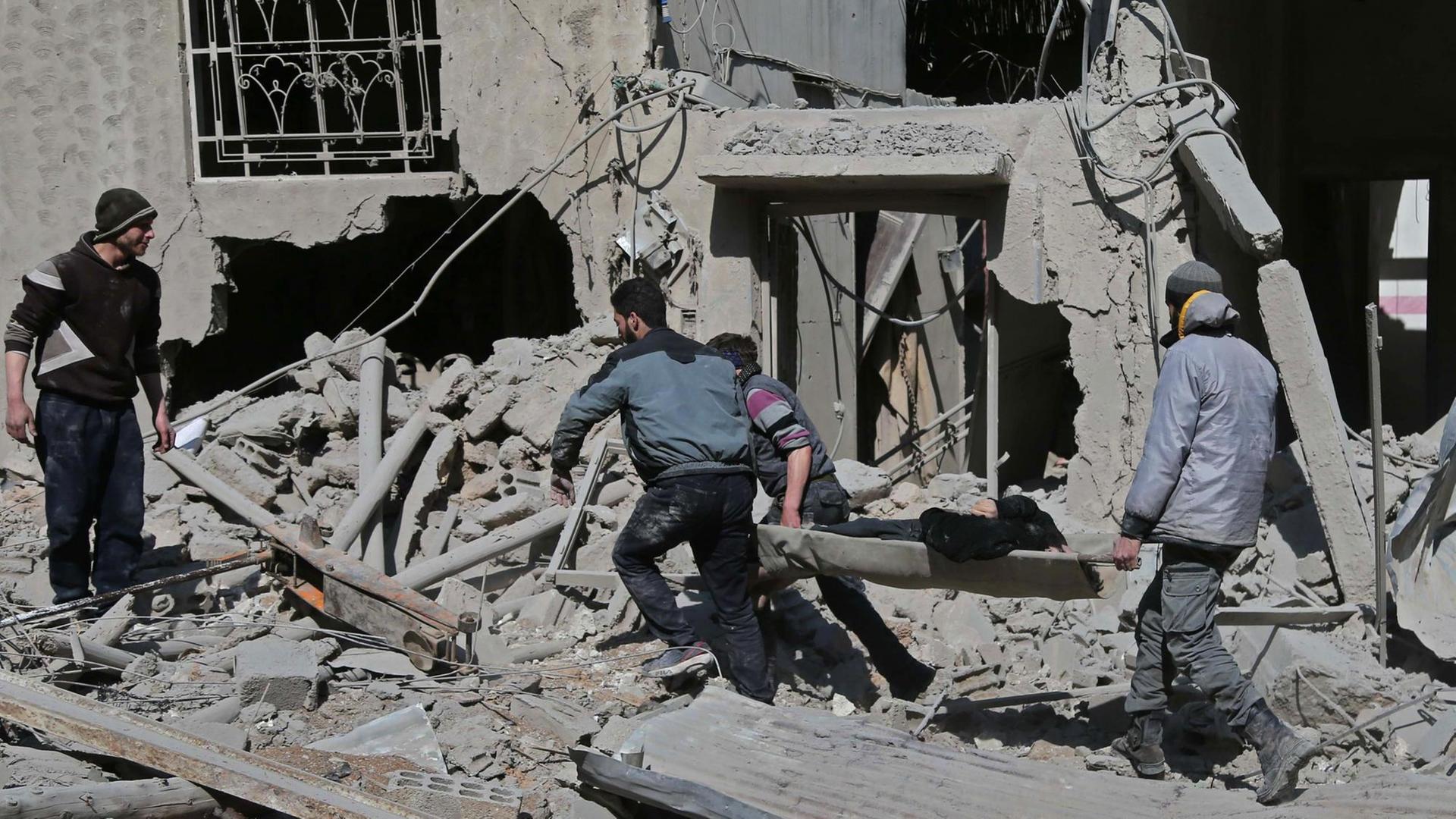 Ein Mann wird auf einer Trage aus Trümmern in der Stadt Hamouria, Ost-Ghouta, gerettet.