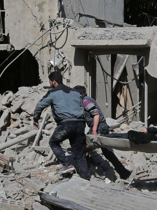 Ein Mann wird auf einer Trage aus Trümmern in der Stadt Hamouria, Ost-Ghouta, gerettet.