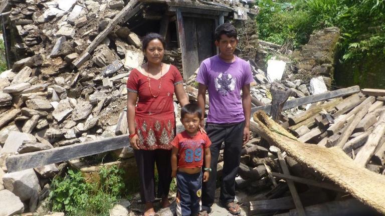 Buddhi und Sarita mit ihrem Sohn Krishna vor ihrem zerstörten Haus in den Bergen Nepals.