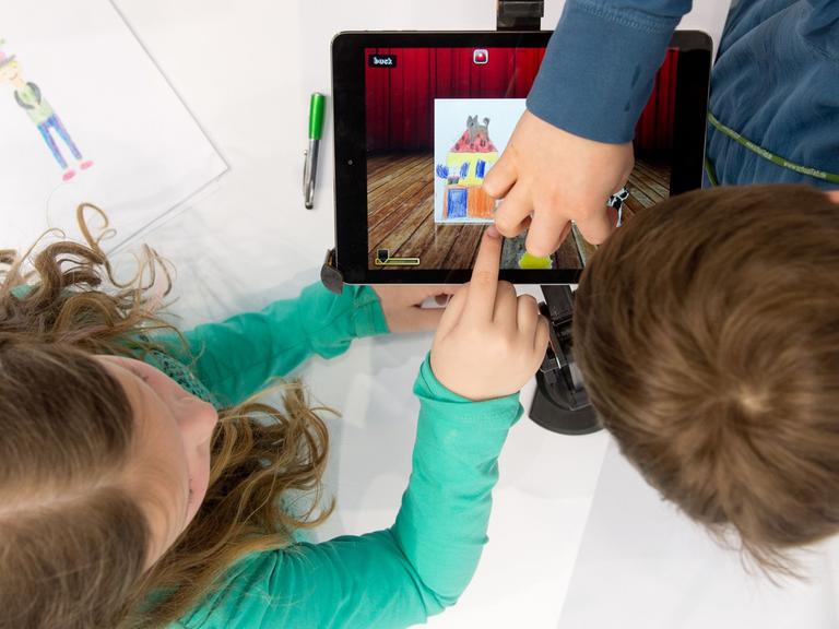 Kinder arbeiten am 25.03.2014 auf der Bildungsmesse Didacta in Stuttgart (Baden-Württemberg) an dem Messestand des Madsack Mediastore an einem iPad. Die Bildungsmesse läuft vom 25. bis 29.03.2014.