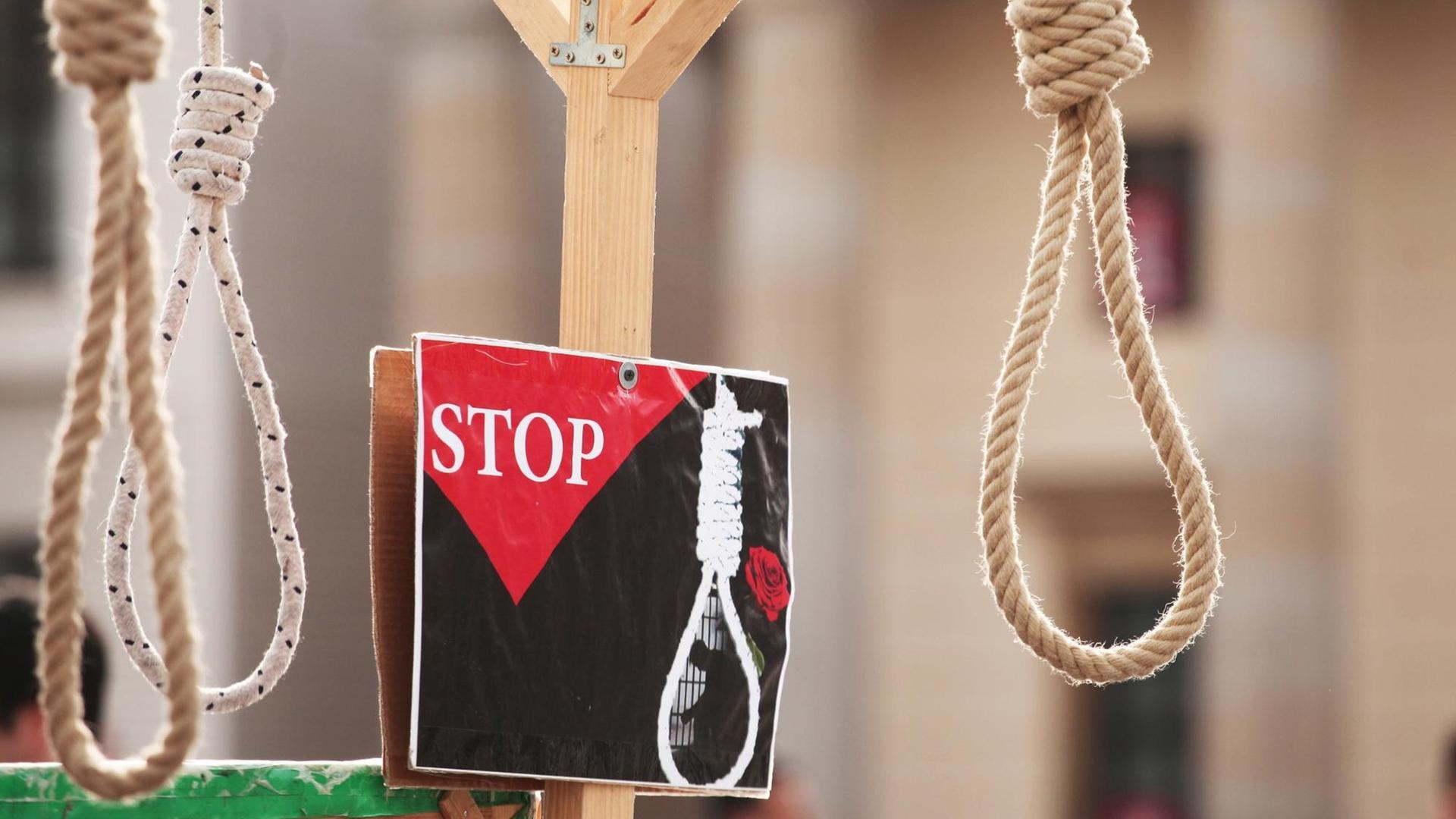 Bei einer Aktion gegen Hinrichtungen im Iran vor dem Brandenburger Tor in Berlin hängen am 31.03.2017 symbolisch Henkersschlingen von einem Galgen.