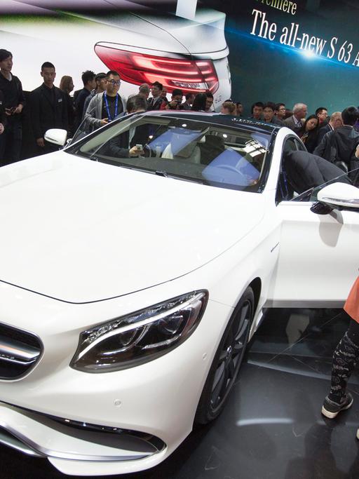 Fotografen, Journalisten und eine Messehostess stehen um einen weißen AMG-Mercedes.