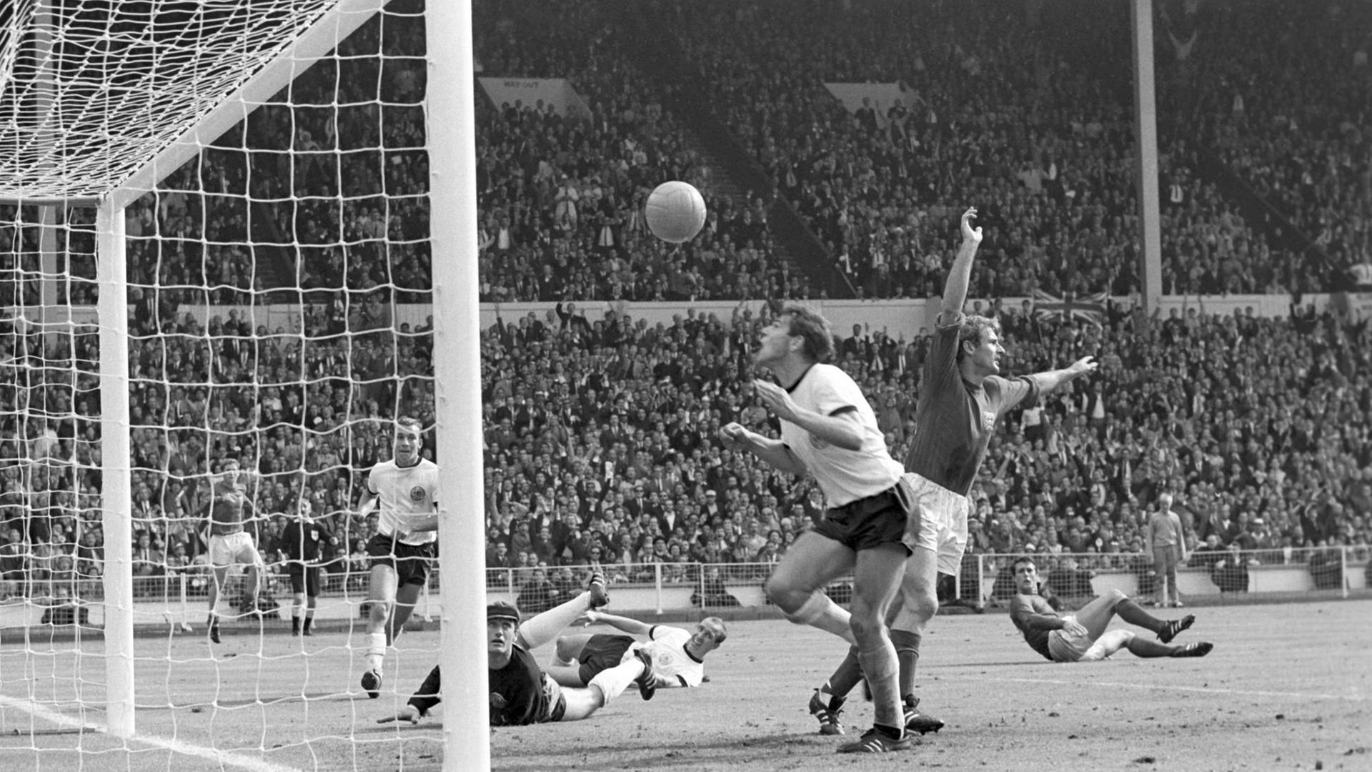 Beschreibung: Fußball-WM 1966 - Finale - England - Deutschland 4:2 n.V. - Szene direkt nach dem Wembley-Tor: Wolfgang Weber (DEU, vorne) köpft den Ball über das Tor, rechts hinter ihm Roger Hunt und Geoff Hurst (beide ENG)