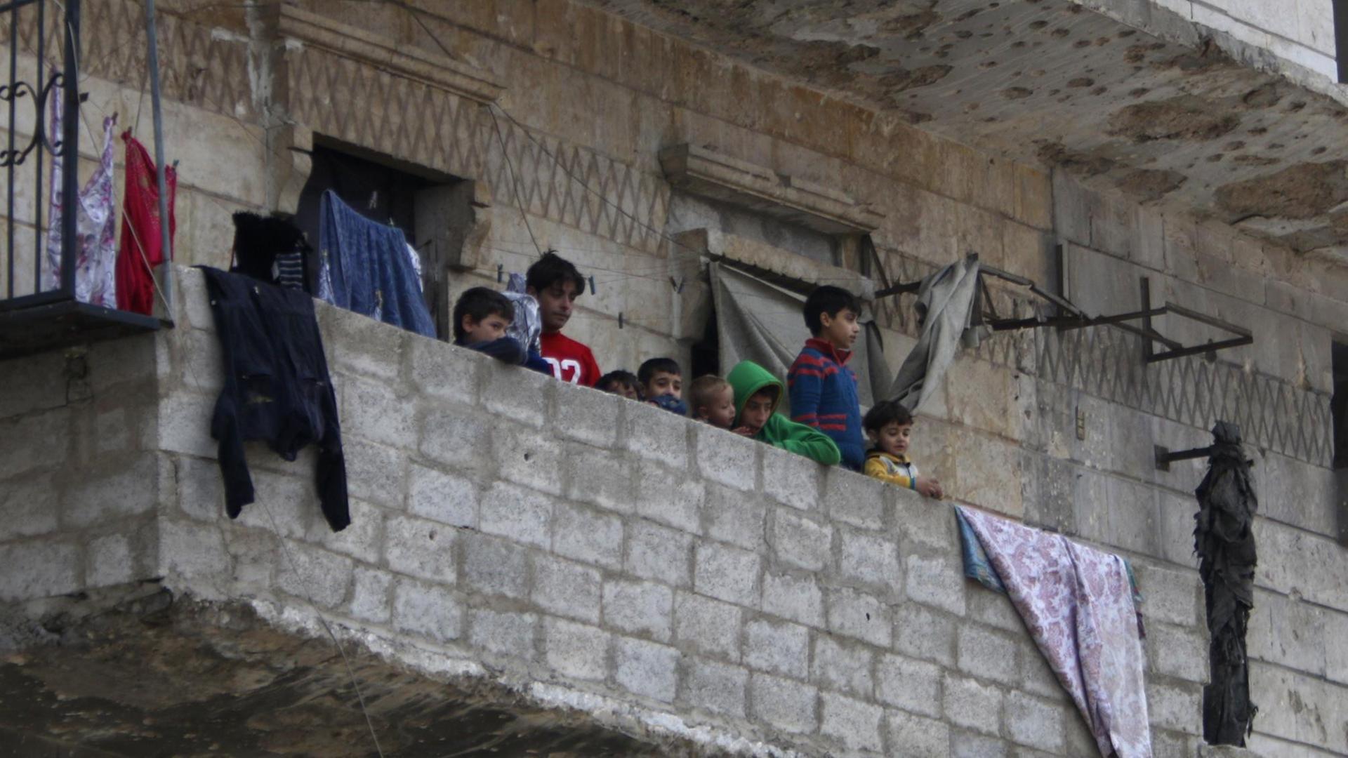Einwohner Aleppos auf dem Balkon ihres zerstörten Hauses.